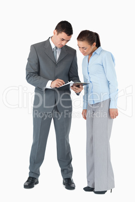Business partner having a look at a clipboard against a white ba
