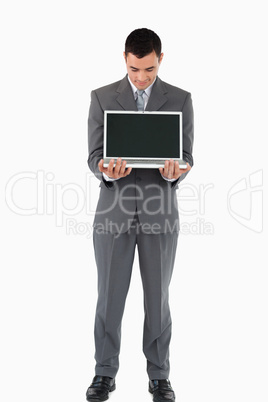 Businessman standing with his laptop against a white background