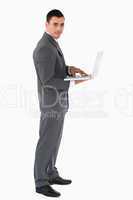 Confident businessman with laptop against a white background