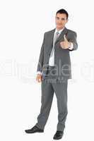 Young businessman giving thumb up
