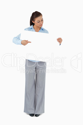 Young businesswoman looking at the sign she is presenting