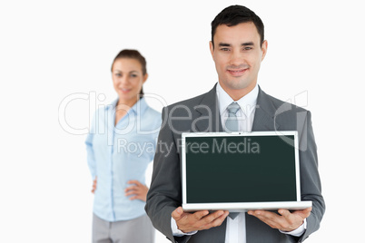 Businessman presenting laptop with businesswoman in the backgrou