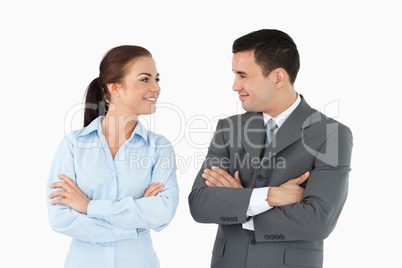 Business partners with arms folded looking at each other