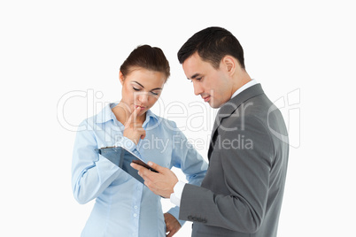 Business partners analyzing document on the clipboard