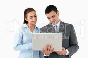 Young business partners looking at laptop