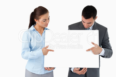 Business partners pointing at sign they are presenting