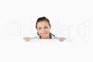 Businesswoman looking over wall