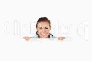 Smiling businesswoman looking over wall