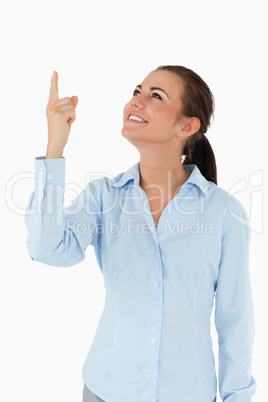 Smiling businesswoman looking and pointing upwards