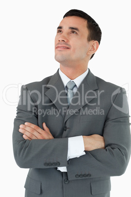 Businessman with arms folded looking diagonally upwards