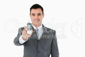 Smiling businessman showing his phone