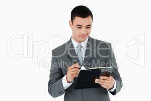 Businessman writing on clipboard