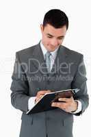 Businessman taking notes on clipboard