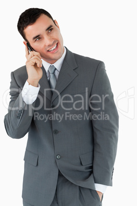 Smiling businessman looking diagonally upwards while on the phon