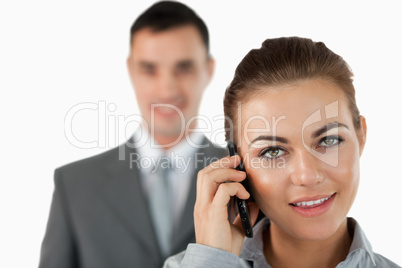 Close up of businesswoman on the phone with colleague behind her