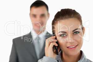 Close up of businesswoman on the phone with colleague behind her