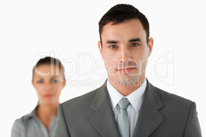 Close up of serious looking businessman with colleague behind hi