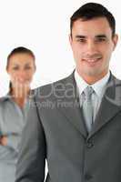 Close up of smiling businessman with colleague behind him