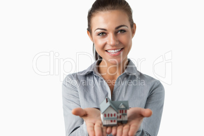 Female estate agent holding miniature house in her hands