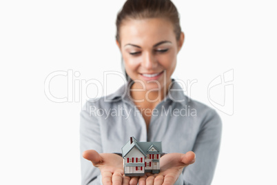 Miniature house being held by female estate agent