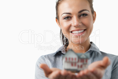 Female estate agent presenting miniature house