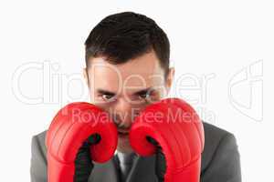 Close up of businessman with boxing gloves taking cover