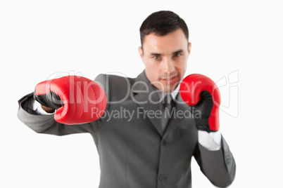 Close up of businessman with boxing gloves striking a hook