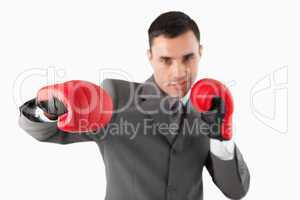 Close up of businessman with boxing gloves striking a hook