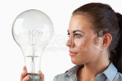 Businesswoman looking at huge light bulb in her hand