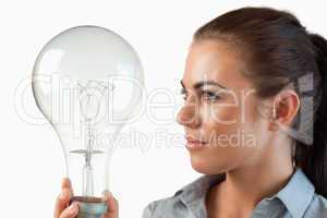 Businesswoman looking at huge light bulb in her hand