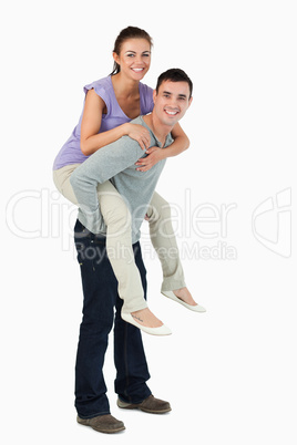 Young male carrying his girlfriend piggyback