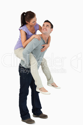 Young female carried piggyback by her boyfriend