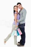 Young male hugging his girlfriend during shopping tour