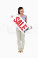 Young female looking at sales sign in her hands