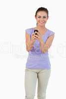 Smiling young female holding her cellphone
