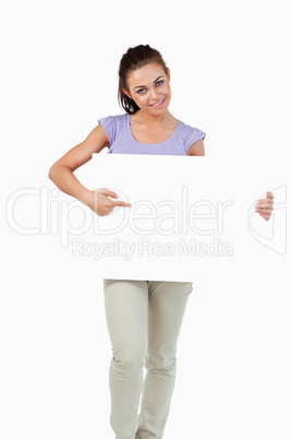 Young female pointing at banner in her hands