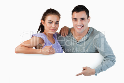 Young couple presenting advertisement