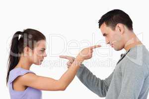 Young couple pointing at each other
