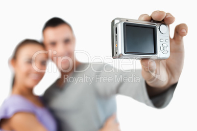 Camera being used to take a picture of young couple