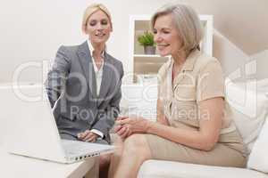 Saleswoman Advising a Senior Woman on Laptop Computer