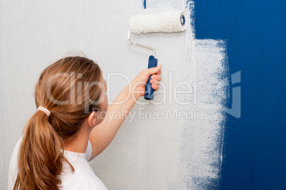 Woman painting a wall