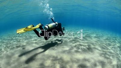 High angle view of a scuba diver in shallow sandy bay