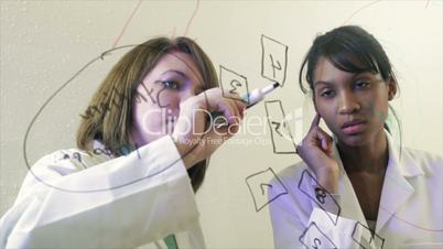 lab techs writing on the clear board