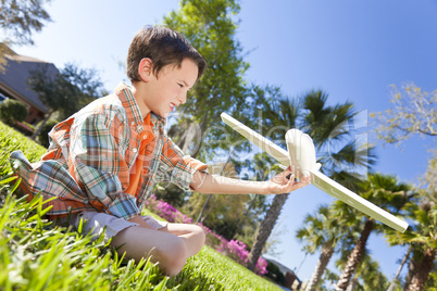 Young Boy Playing WIth Model Airplane Outside