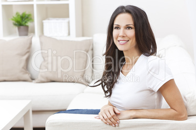 Happy Smiling Beautiful Woman Sitting on Sofa