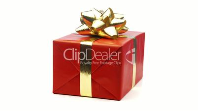 large red christmas present with golden ribbon looping