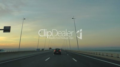 Driving car in highway at sunset