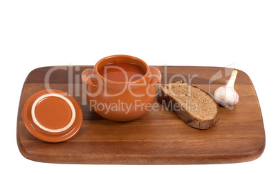 Borsch with bread and garlic on wooden kitchen board
