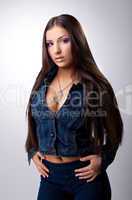 Sexy young brunette posing in jeans costume