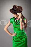 woman posing in green dress and hair style hat